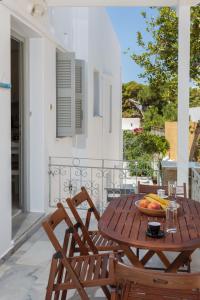 Heart of Paros Apartments في كامبوس باروس: طاولة خشبية وكرسيين على الفناء