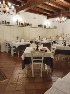 Albergo Grobberio في سان مارتينو بون ألبرغو: غرفة طعام مع طاولات بيضاء وكراسي بيضاء