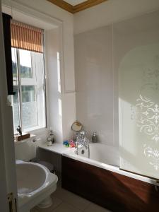 a bathroom with a tub and a toilet and a sink at Rosebank House Bed & Breakfast in Strathyre