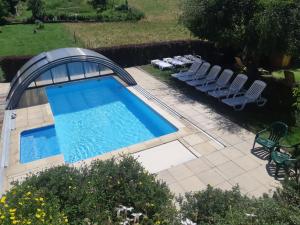 - une vue sur la piscine et ses chaises longues dans l'établissement Hôtel Restaurant La Buffe, à Autrans