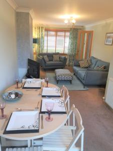 a living room with a table and a couch at Highland Home From Home in Inverness