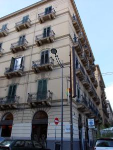 un grande edificio bianco con balconi su strada di B&B L'Orlando Furioso a Palermo