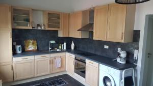 a kitchen with wooden cabinets and a washer at Middeldiek Hooksiel in Wangerland