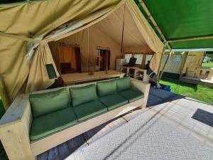 - un canapé installé à l'intérieur d'une tente dans l'établissement Safaritent op Camping la Douane, à Vresse-sur-Semois