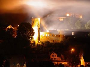 un feu dans un bâtiment avec les lumières allumées dans l'établissement Zum Burgblick, à Burg-Reuland