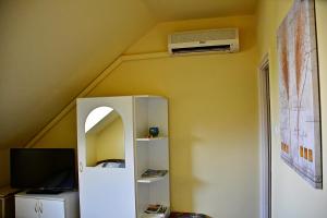 a room with a ceiling with a air conditioner on the wall at Tiszafa Vendégház Nagykanizsa in Nagykanizsa