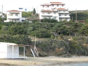 a building on the beach with houses on a hill at Nora Norita in Batsi