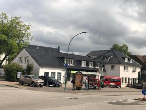 una luz de la calle con coches estacionados frente a un edificio en Apartment BLN en Oststeinbek