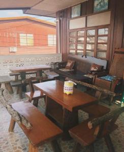 een kamer met tafels en stoelen en een bank bij ซอยห้า โฮมสเตย์ เชียงคาน in Chiang Khan