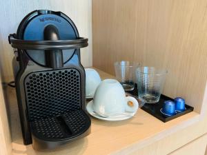 a coffee maker sitting on a shelf with glasses at Casa Bodhi Boutique Hotel & Spa in Marbella
