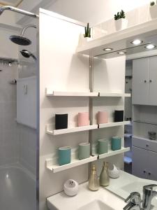 a bathroom with white shelves and a sink at E&M Apartments Düsseldorf in Düsseldorf