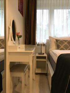 a bedroom with a bed and a desk with a mirror at E&M Apartments Düsseldorf in Düsseldorf
