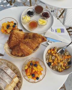a white table with plates of food on it at Hôtel Le Sud in Juan-les-Pins