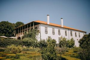 ein großes weißes Gebäude mit zwei Kaminen oben in der Unterkunft Hotel Rural Casa dos Viscondes da Varzea in Lamego