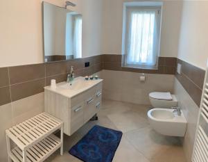 a bathroom with a sink and a toilet and a mirror at Casa Mìtìlà in Bardolino +39 photos
