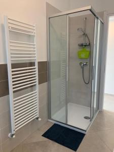 a shower with a glass door in a bathroom at Casa Mìtìlà in Bardolino