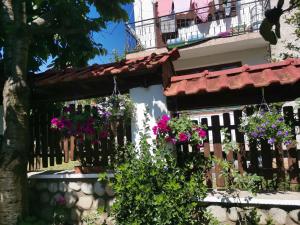 a building with flowers hanging from a fence at Boutique Guest House IKONOMOV in Bansko