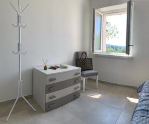 a bedroom with a dresser and a bed and a window at Casa Mìtìlà in Bardolino