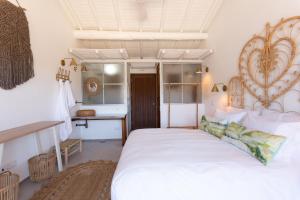 a bedroom with a large white bed and a desk at Hortas do Rio - Casa de Campo in Carrapateira +32 photos