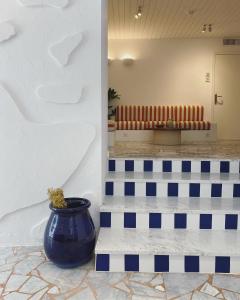 a blue vase sitting on top of a tile floor at Hôtel Le Sud in Juan-les-Pins