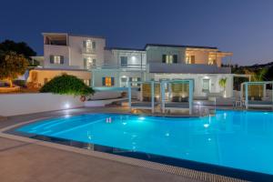 a large swimming pool in front of a house at Aegean Paradiso Vacation Club in Azolimnos Syros