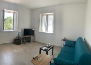 a living room with a blue couch and a tv at Casa Mìtìlà in Bardolino