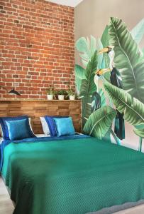 um quarto com uma grande cama verde e uma parede de tijolos em Welcome Apartment Nevsky em São Petersburgo
