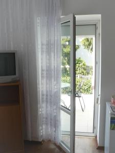 a sliding glass door to a balcony with a television at Villa pod Topolami in Okuninka