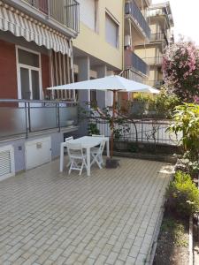 a patio with an umbrella and a table and chairs at casa blu in Follonica