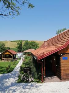 un edificio con techo rojo y un patio con flores en Pod orehom drvena kuća i sauna, en Krapina