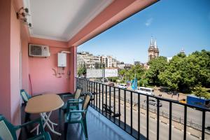 a balcony with a table and chairs and a view of a city at Apartment Chavchavadze in Batumi