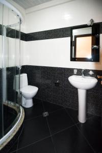 a bathroom with two toilets and a sink and a shower at Apartment Chavchavadze in Batumi