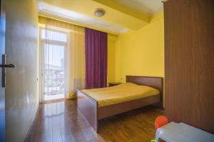 a small bedroom with a bed and a window at Apartment Chavchavadze in Batumi