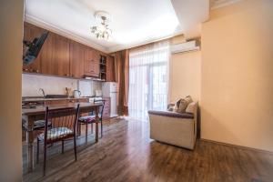 a kitchen and living room with a couch and a table at Apartment Chavchavadze in Batumi +11 photos