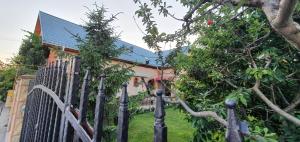 a fence in front of a house with a tree at Vila Vasile in Mamaia Sat/Năvodari