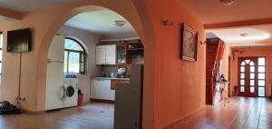 a kitchen with an archway and an orange wall at Vila Vasile in Mamaia Sat/Năvodari