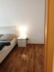 ein Schlafzimmer mit einem Bett und einer Lampe auf einem Nachttisch in der Unterkunft KIC Kochschule in Colditz Gastroverleih, Mietkoch, HMDL, FEWO in Colditz