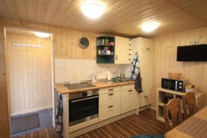 タンバッハ・ディータルツにあるFerienhaus Am Waldの白いキャビネットとコンロ付きオーブンを備えたキッチン