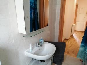 uma casa de banho com um lavatório branco e um espelho. em KIC Kochschule in Colditz Gastroverleih, Mietkoch, HMDL, FEWO em Colditz