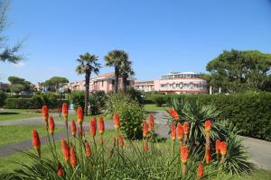 un giardino con fiori rossi di fronte a un edificio di Sunny terrace apartament a Cavallino-Treporti