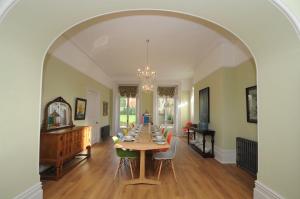 een boog in een woonkamer met een tafel en stoelen bij The Quays Mansion in Christchurch in Christchurch