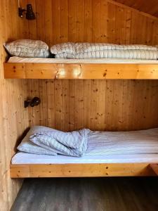 two bunk beds in a wooden cabin at Nesheim Hytter & Camping in Bjordal