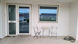 two chairs and a table in front of a house at Fossagil 2 in Akureyri