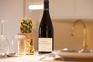 eine Flasche Wein auf einem Tisch mit einem Kaktus in der Unterkunft THEATRE 9 in Dijon