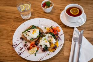 a plate with eggs and toast and a cup of tea at Apartamenty Tespis - Francuska Atal Park in Katowice