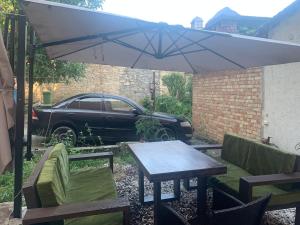 a table and chairs under an umbrella next to a car at Apartment on Pastukhova 31 in Pyatigorsk