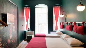 a bedroom with a bed with red curtains and a window at Casa Rosa Suites in Istanbul