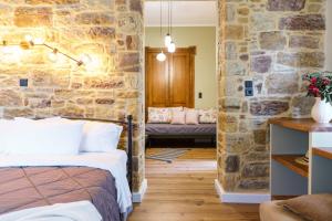 a room with a bed and a stone wall at Voulamandis House in Kambos