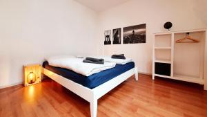 a white bed in a room with a wooden floor at Zentrales Dachgeschoss-Apartment Bielefeld in Bielefeld