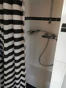 a bathroom with a shower with a black and white shower curtain at loft boat in Amsterdam